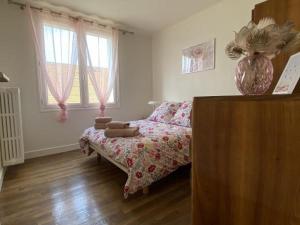 sypialnia z łóżkiem i wazonem na komodzie w obiekcie Magnifique T3 au centre, jardin privatif, proche thermes, wifi, parking, jeux extérieurs, lave-linge/sèche-linge - FR-1-541-94 w mieście La Roche-Posay +5 zdjęć