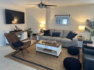 a living room with a couch and a table at Three Treasures Beach House in New Smyrna Beach