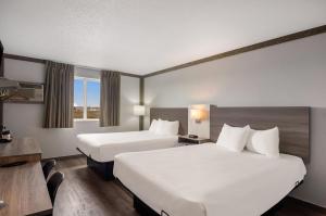 una camera d'albergo con 2 letti e una scrivania di Econo Lodge Scottsbluff a Scottsbluff