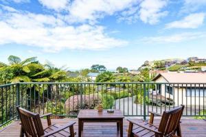 a patio with two chairs and a table on a balcony at Unit 10 Kaiteri Apartments and Holiday Homes in Kaiteriteri