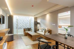 a living room with a dining table and a bedroom at Shambhala Hotel Pattaya - SHA Plus in Pattaya Central