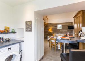 een keuken en een woonkamer met een tafel en een eetkamer bij Canadian Beach Hut in Bénerville-sur-Mer