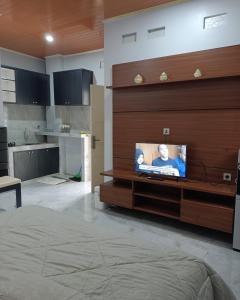 sala de estar con TV de pantalla plana en la pared en Anyak's place Syariah, en Yogyakarta