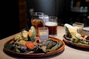 a table with two plates of food and glasses of beer at Dagedan House 金崙海邊民宿 in Taimali