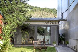uma extensão de vidro de uma casa com uma mesa e cadeiras em 打個蛋海旅DagedanHouse金崙海邊民宿 em Taimali
