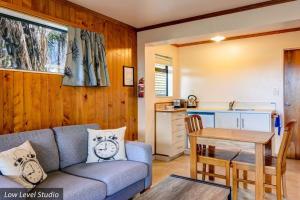 ein Wohnzimmer mit einem Sofa und einem Tisch in der Unterkunft Unit 11 Kaiteri Apartments and Holiday Homes in Kaiteriteri