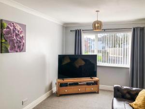 a living room with a flat screen tv on a stand at The Larches in Aspatria