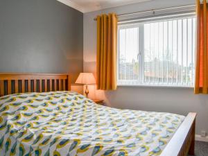 a bedroom with a large bed and a window at The Larches in Aspatria