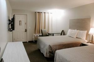 a hotel room with two beds and a door at Berlin Village Inn in Berlin