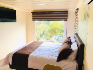 a bedroom with a bed in front of a window at Hostería Ojo de Agua in Loreto