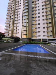 een zwembad voor een hoog gebouw bij Sabina's condo @Mesaverte in Cagayan de Oro