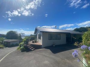 a small white house with a driveway at Unit 12 Kaiteri Apartments and Holiday Homes in Kaiteriteri