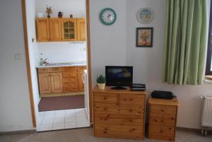 a kitchen with a dresser with a television and a clock at M+M Apartmán in Harrachov