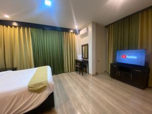 a hotel room with a bed and a flat screen tv at Eight Breeze in Baclayon