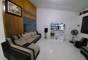 uma sala de estar com sofás e uma televisão de ecrã plano em Pucallpa House3 em Pucallpa