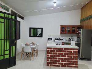 a kitchen with a refrigerator and a table and chairs at Pucallpa House3 in Pucallpa