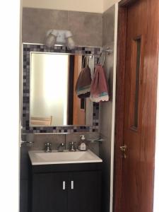 W łazience znajduje się umywalka i lustro. w obiekcie Las Lavandas Purmamarca w mieście Purmamarca