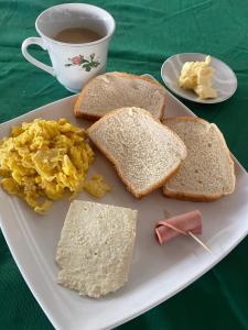 a plate with scrambled eggs and toast and a cup of coffee at Hotel Palma Azul Beach in Coveñas