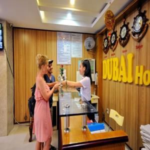 a couple of people are standing at a counter at Dubai Nha Trang Hotel managed by HT in Nha Trang