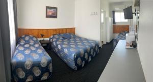 Pokój z 2 łóżkami i biurkiem w obiekcie Tamworth Budget Motel w mieście Tamworth