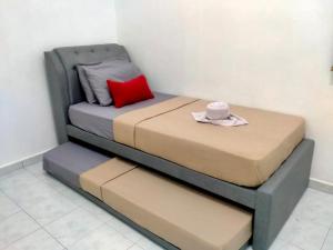 a bed with a hat sitting on top of it at Nur Kasih Homestay Seri Manjung in Seri Manjung