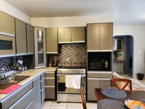 a kitchen with a stove top oven next to a table at Apartment Downtown Cananea in Cananea
