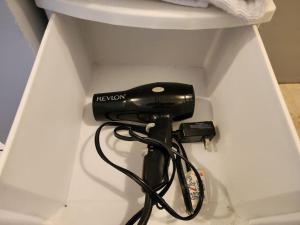 a black hair dryer in the corner of a toilet at Apartment Downtown Cananea in Cananea