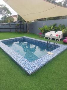 a swimming pool in a yard with an umbrella at My Pool House in Alor Setar