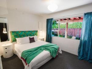 a bedroom with a large bed and a window at Mon Coeur Holiday Home in Kaiteriteri