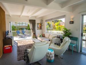 - un salon avec un canapé et des chaises dans l'établissement Mon Coeur Holiday Home, à Kaiteriteri