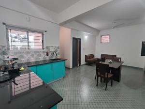a kitchen with a table and a blue cabinet at Navilu Homes in Mysore