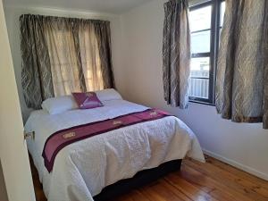 a small bedroom with a bed with a window at Richmond Central 3bdrm House sleeps 7 in Richmond