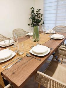 uma mesa de madeira com pratos e copos de vinho em Hermosa casa para conocer León em León