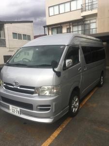 a silver van parked in a parking lot at Thanyaporn Hotel in Takayama