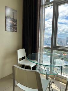 uma mesa de vidro e cadeiras num quarto com uma janela em Fully furnished 1 BR Condo unit em Manila