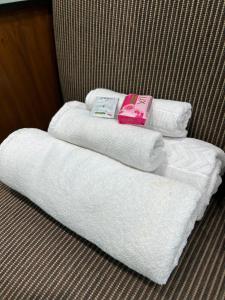 two towels and two pillows sitting on a bed at Teakwood Suite - Nokha House in Kolkata