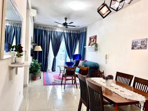 a dining room and living room with a table and chairs at Casarozza Homestay, Southville City in Bangi
