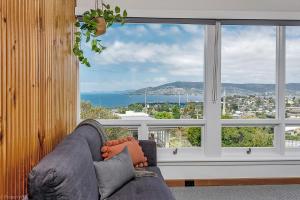 a living room with a couch and a large window at Bella Vista on Beach in Hobart