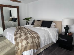 a bedroom with a bed with a large mirror at Jetty beach shack in Coffs Harbour