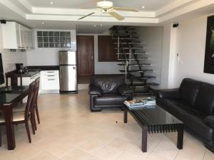 uma sala de estar com mobiliário de couro preto e uma escada em espiral em Andaman Hill Pool Seaview em Patong Beach