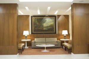 a living room with a couch and two tables and a painting at Casablanca Center Hotel in Petrópolis