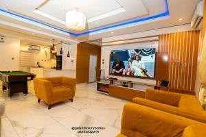 a living room with a tv and a pool table at Gillant Luxury Homes in Benin City