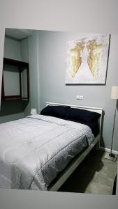 a bedroom with a bed with a painting on the wall at The Gulch in Douala