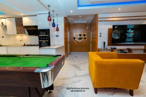 Gillant Luxury Homes في بنين سيتي: غرفة معيشة مع طاولة بلياردو وكرسي اصفر