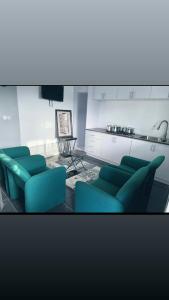ein Wohnzimmer mit blauen Stühlen und einem Tisch in der Unterkunft The Gulch in Douala