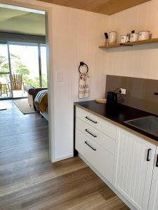 a kitchen with white cabinets and a counter top at Aquila Eco Retreat in Richmond