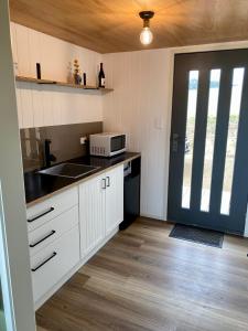 a kitchen with a sink and a microwave at Aquila Eco Retreat in Richmond
