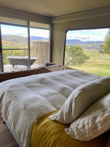 a bedroom with a large bed with a view of a tub at Aquila Eco Retreat in Richmond