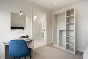 1 dormitorio con escritorio y silla azul en The Stables At Mullans Bay en Kesh
