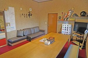 sala de estar con sofá y mesa en 日本庭園古民家　飯田屋　Traditional experience iidayajapan, en Yokohama